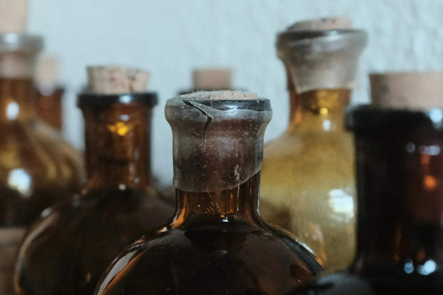 Frascos y morteros antiguos de farmacia junto a un manuscrito médico abierto, con luz cálida.