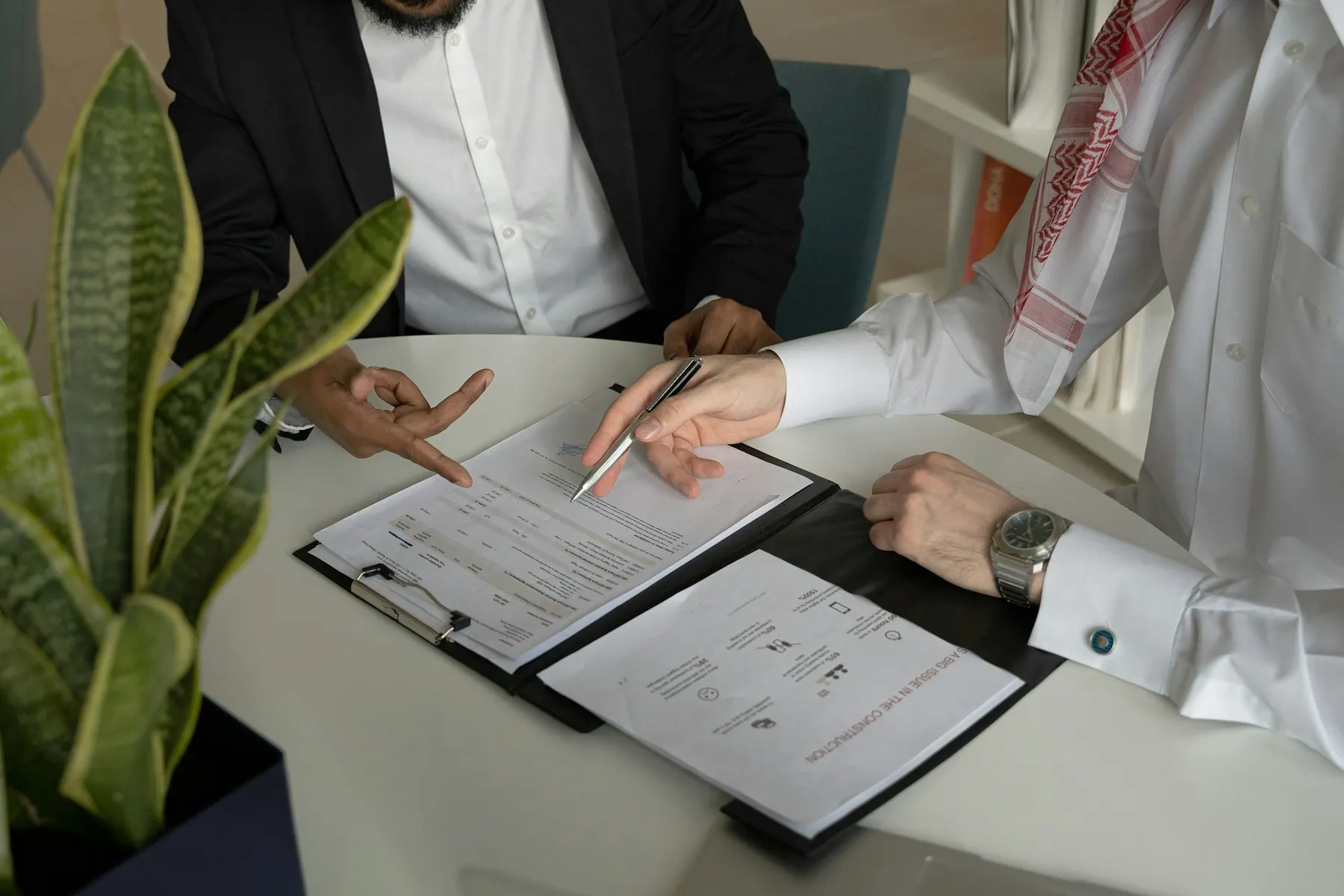 Una pareja firma su contrato de matrimonio ante un funcionario; solo se ven las manos y los documentos.