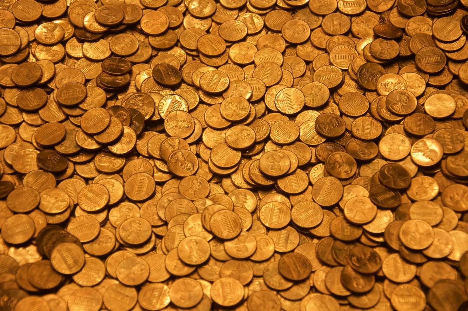 Un manuscrito antiguo con escritura árabe junto a monedas de plata sobre una mesa de madera.