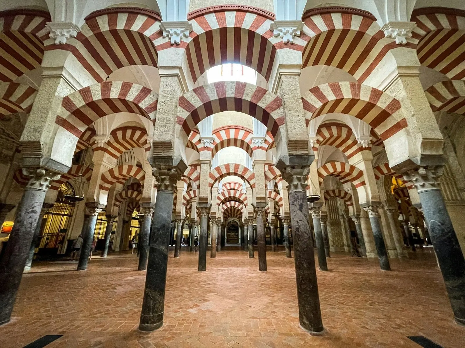 Patio interior de estilo andalusí en Córdoba, con arcos de herradura y una fuente, sin personas.