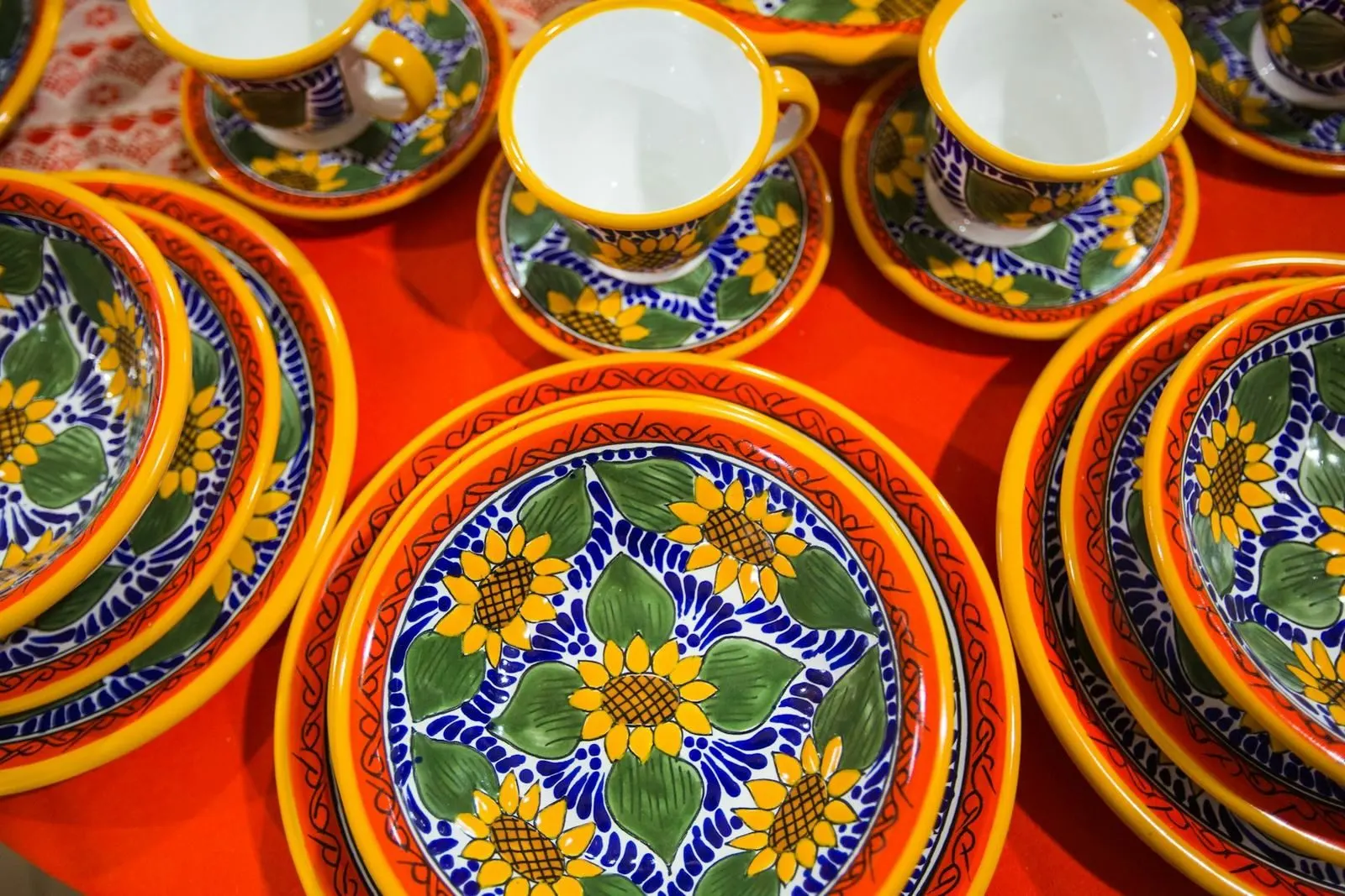 Un plato de talavera poblana de azul y blanco sobre una mesa de madera clara.