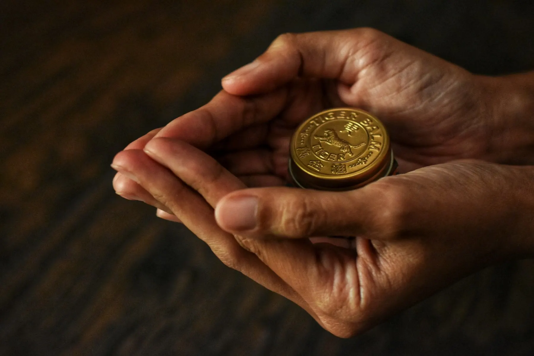 Unas manos sostienen con cuidado una moneda de oro.